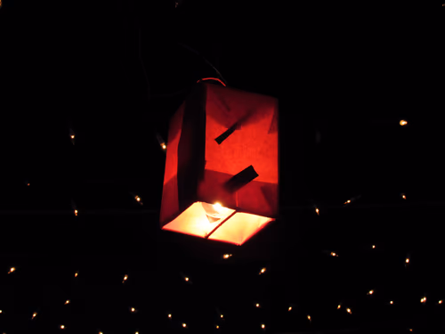 Retro Light Bulb Glowing from string hanging on city decoration celebration