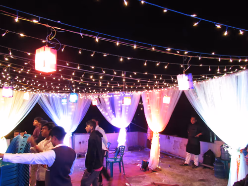 Retro Light Bulb Glowing from string hanging on city decoration celebration