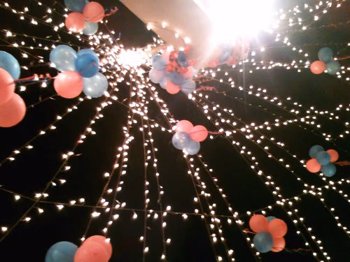 Retro Light Bulb Glowing from string hanging on city decoration celebration